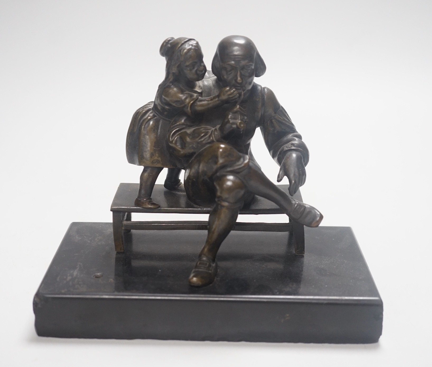 A 19th century bronze group of a gentleman smoking a pipe and a girl, on slate base 18.5cm wide